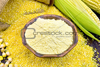 Flour corn in bowl with grains on board