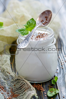 Jar with homemade yogurt and flax seeds.