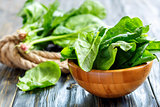 Fresh spinach leaves in a wooden bowl.
