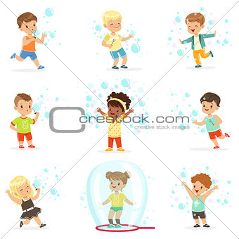 Cute little girls and boys blowing and playing soap bubbles
