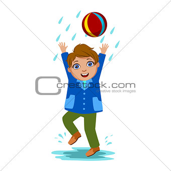 Boy Playing With The Ball, Kid In Autumn Clothes In Fall Season Enjoyingn Rain And Rainy Weather, Splashes And Puddles