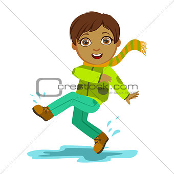 Boy Kicking Water With Foot, Kid In Autumn Clothes In Fall Season Enjoyingn Rain And Rainy Weather, Splashes And Puddles