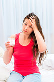 woman with a headache and a glass in his hand drugs