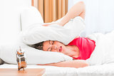 woman covering her ears pillows and fell asleep