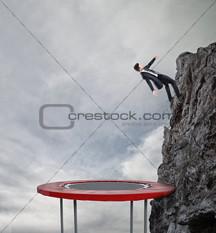 Businessman jumping on a trampoline to reach the flag. Achievement business goal and Difficult career concept