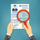 Hands holding a resume and a magnifying glass.