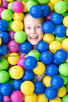 Smiling child in colored balls