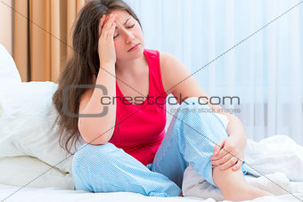 young woman with a headache in bed