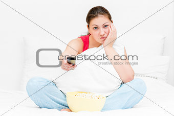 girl in pajamas with remote control TV dissatisfied