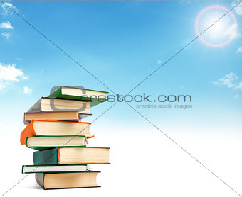 A stack of books on white floor against blue sky