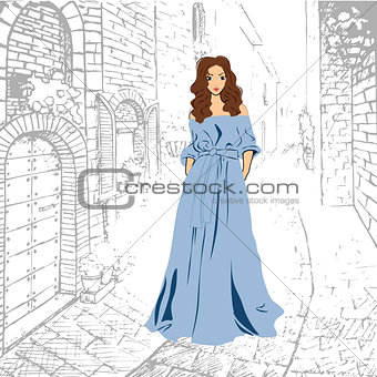 Fashionable romantic girl in blue maxi dress walking down the street