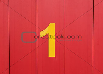 the number one, yellow, set against bright red wood