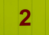 the number two, red, set against bright yellow wood