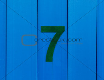 the number seven green, set against bright blue wood