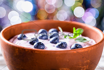 yogurt with blueberries and mint, bokeh background. selective fo