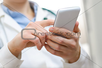 A female doctor texting on smartphone