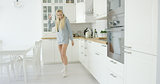 Lovely young girl dancing in kitchen