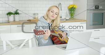 Female guitarist practicing at home