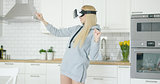 Woman in VR glasses in kitchen