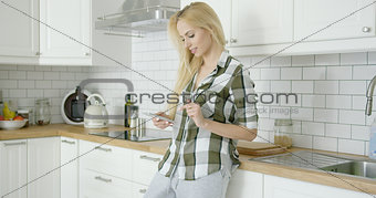 Lovely woman with phone in kitchen