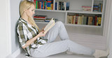 Woman sitting on floor with book