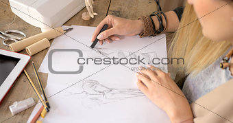 Crop shot of dressmaker drawing sketches
