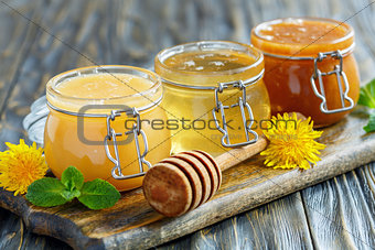 Different varieties of honey in glass jars.