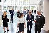Businesspeople In Busy Lobby Area Of Modern Office