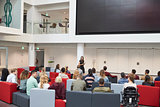 Students at a lecture in university atrium, back view