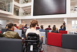 Back view of students at a lecture in a university atrium