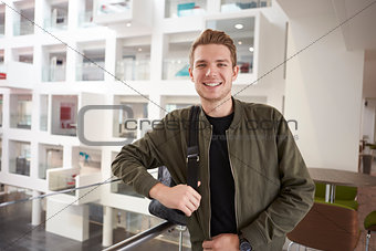 Young adult male student smiling on mezzanine in university