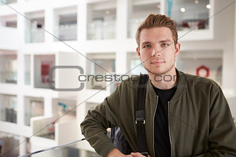 Portrait of young adult male student on mezzanine in university