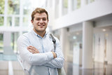 Smiling adult male student in modern university lobby