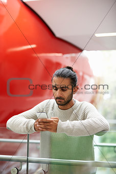 Asian male university student using smartphone, vertical