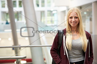 Smiling blonde haired female student in university building