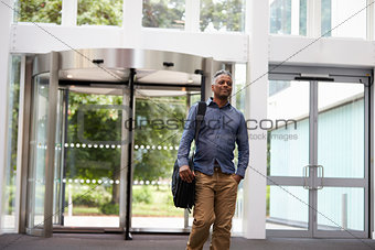 Middle aged black man in the foyer of a large modern building