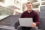 Portrait Of Male University Student Using Laptop On Campus