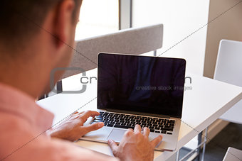 View Over The Shoulder Of Male Student Using Laptop