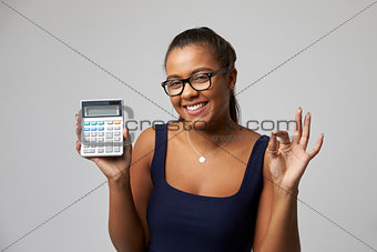 Studio Portrait Of Female Accountant Using Calculator