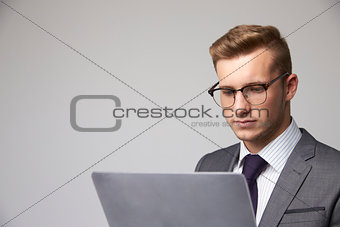Studio Portrait Of Businessman Using Laptop