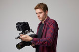 Studio Portrait Of Male Videographer With Film Camera
