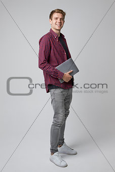 Studio Portrait Of Casually Dressed Businessman With Laptop
