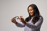 Studio Portrait Of Female Optician Looking At Spectacles