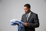 Studio Portrait Of Male Fashion Buyer Looking At Shirts