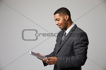 Studio Portrait Of Businessman Using Digital Tablet