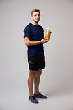 Studio Portrait Of Male Nutritionist With Drinks Bottle