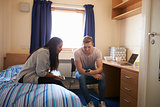 Student Couple Working In Bedroom Of Campus Accommodation