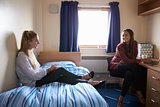 Female Students Working In Bedroom Of Campus Accommodation