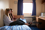 Female Students Working In Bedroom Of Campus Accommodation