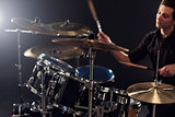Side View Of Young Drummer Playing Drum Kit In Studio